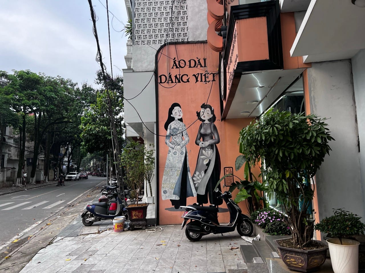 mural of Vietnamese women in áo dài on a building wall in Lao Cai