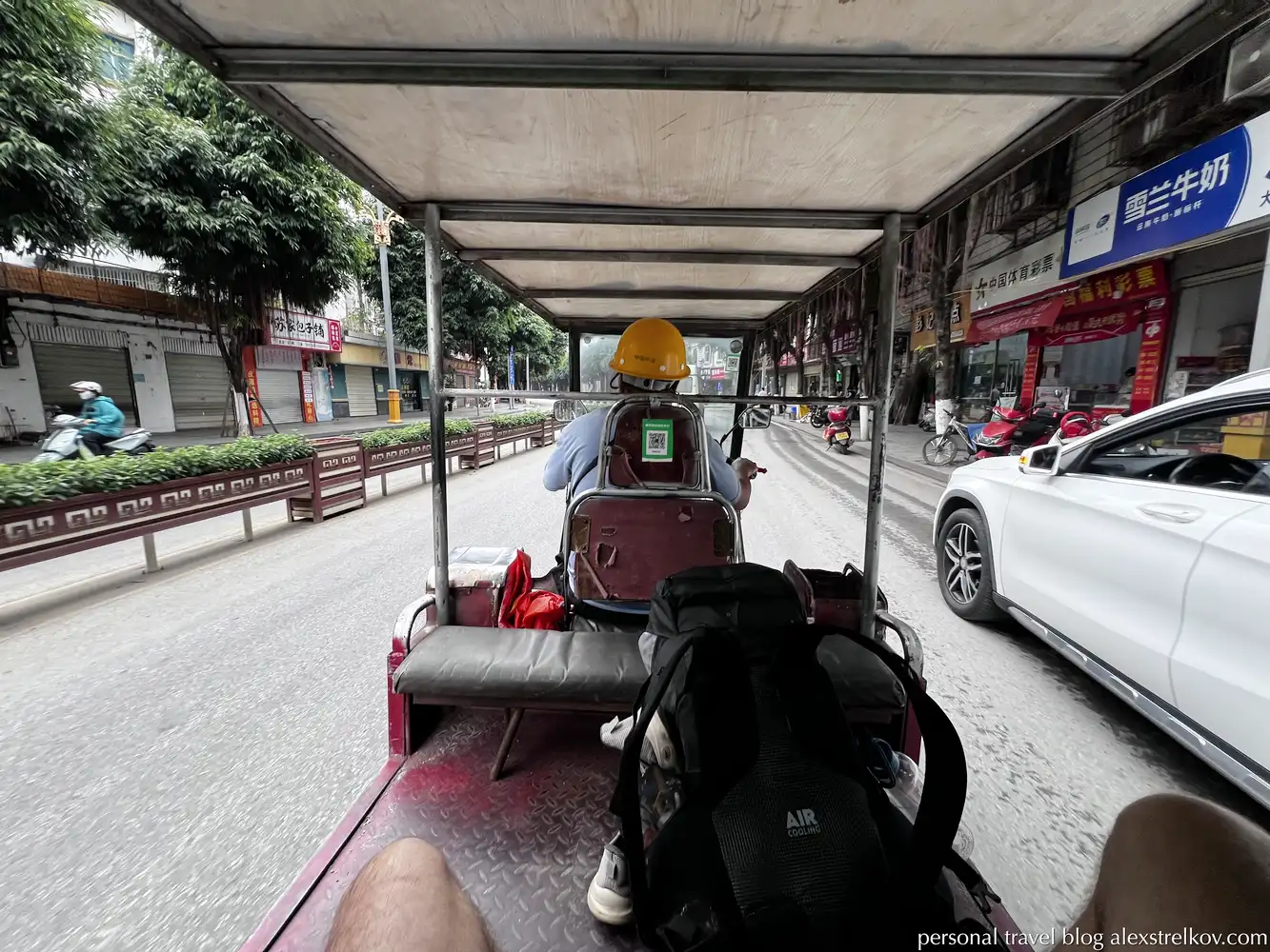 riding electric tuk-tuk Hekou driver yellow helmet 