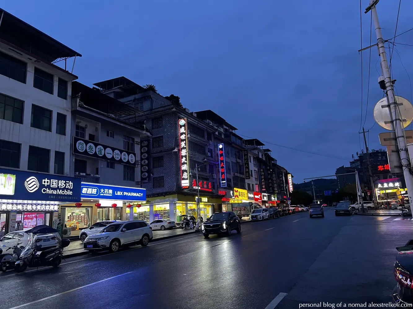 evening street in Furongzhen, lit café signs 
