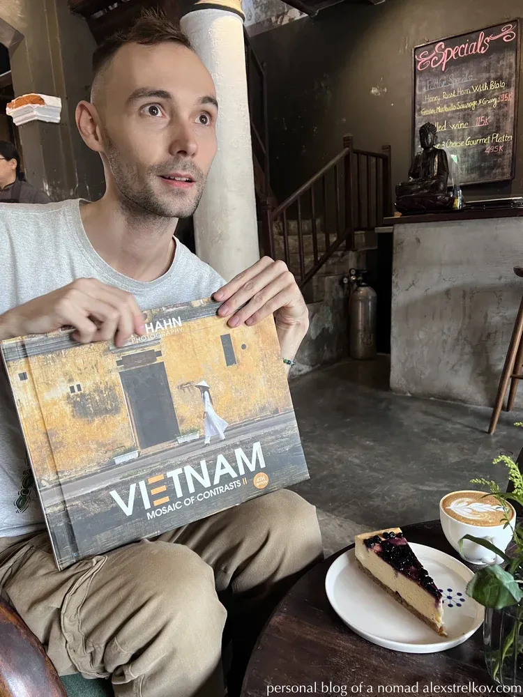 man holding Vietnam Mosaic of Contrasts book cafe cheesecake coffee 
