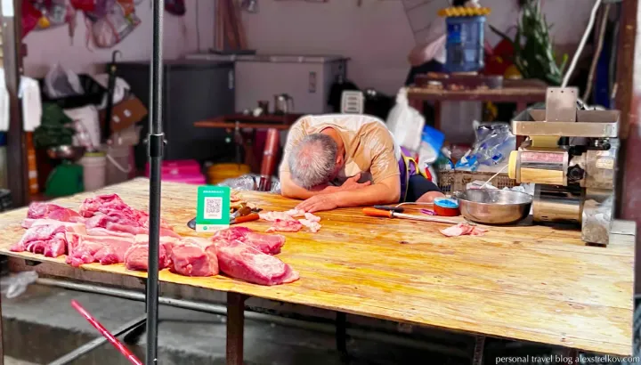 meat vendor sleeping at market stall Hekou China